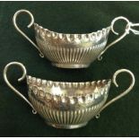 A pair of decorative silver 2 handled salt pots.