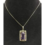 A 9ct gold pendant set with a large baguette amethyst on 9ct gold chain.
