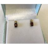 A pair of 9ct gold earrings set with garnets.