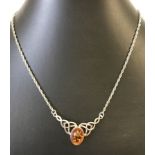 An amber & silver pendant in Celtic design.