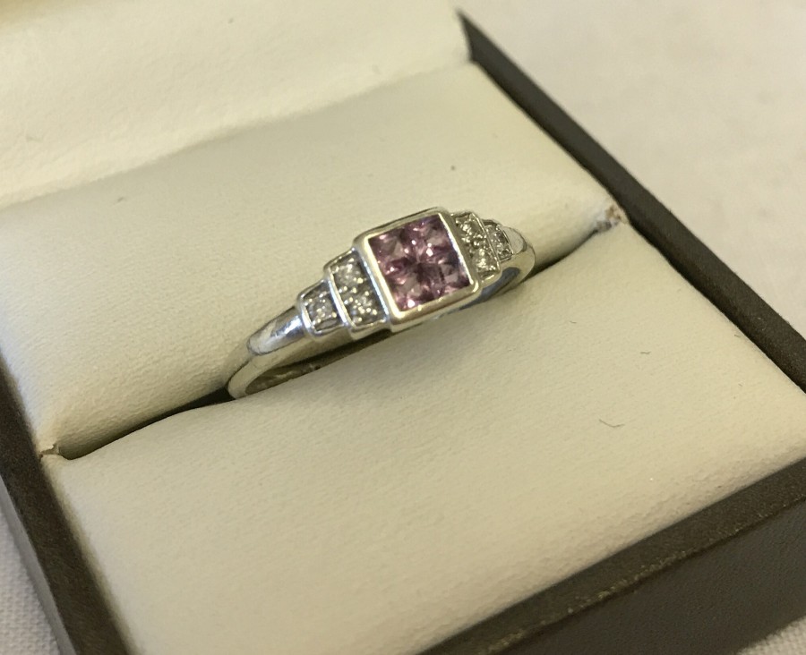 9ct white gold dress ring set with pink sapphires and diamonds.