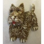 A vintage plastic brooch in the shape of a terrier dog.