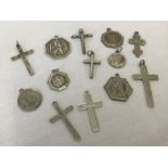 A collection of 7 silver cross pendants and 6 silver St Christopher's medals.