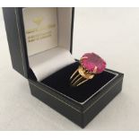 A gold dress ring set with a very large pink created Sapphire.