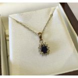 9ct gold pendant set with central blue sapphire encircled by white sapphires.