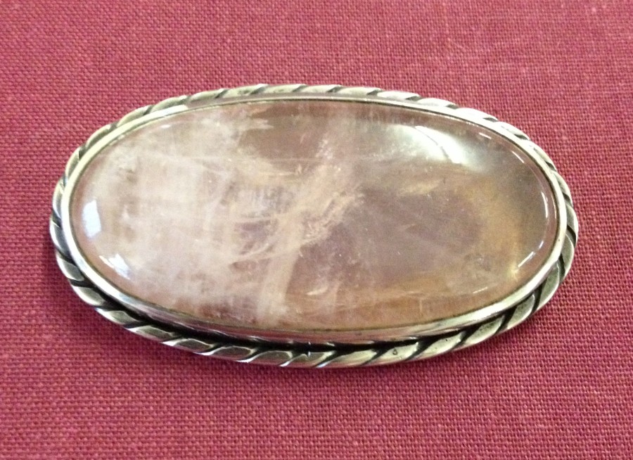 A large rose quartz oval brooch set in silver.