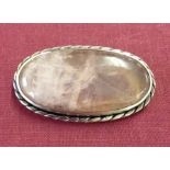 A large rose quartz oval brooch set in silver.