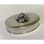 A hallmarked silver oval shaped pill box with rose decoration to top.