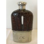 A silver topped hip flask with leather casing to top and silver plate bottom.