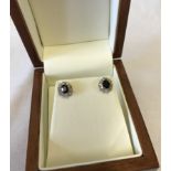 9ct gold earrings set with central oval sapphires surrounded by diamonds.