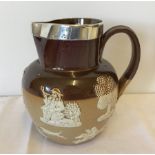 A thick silver rimmed Doulton Lambeth ceramic jug.
