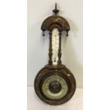 A vintage barometer in carved wood.