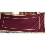 A red velvet undertakers coffin drape trimmed with gold braid.