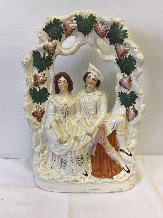 A large Staffordshire flatback figurine "Lovers under Arbour".