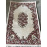 A oriental floral design rug in cream , pink and green colours.