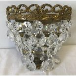 A small ornamental brass mirror backed chandelier style wall light with glass droplets.