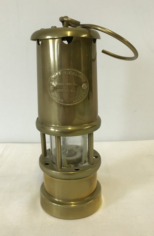 A small brass miner lamp by Lamp and Limelight company of Hockley.