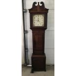 A dark wood long case clock complete with pendulum and weights.