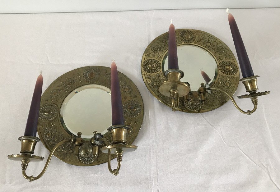 A pair of floral decorated brass mirror backs candle sconces.