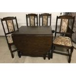 A dark oak drop leaf table and matching chairs.