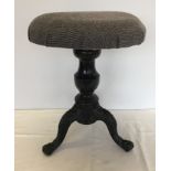 A vintage screw top adjustable piano stool with cast iron tripod feet.