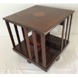 A mahogany revolving table bookcase with inlaid decoration to the top.