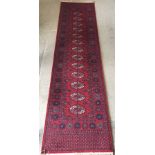 A handmade wool hall runner of red and blue colouration.