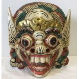 An Indonesian wooden wall hanging Barong mask.