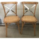 A pair of modern natural oak dining chairs.