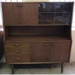 A circa 1970's small sideboard with glass sliding doors and pull down cupboard to top.