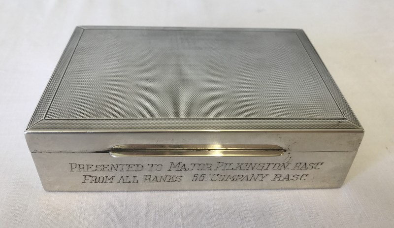 A silver lined wooden cigarette box engraved to front and presented to Major Pilkington. RASC.