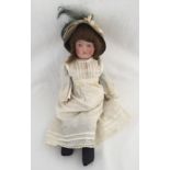 A DURA bisque head doll with soft body in vintage dress.