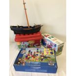 4 large Lego type blocks building toys together with a playmobile ship.