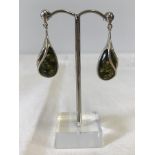 A boxed pair of green amber & silver drop earrings.