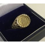 A 9ct gold gents medallion ring with scroll detail to shoulders.