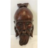 A Thai wooden wall hanging face mask.