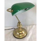 A brass based reading desk lamp with green glass shade.