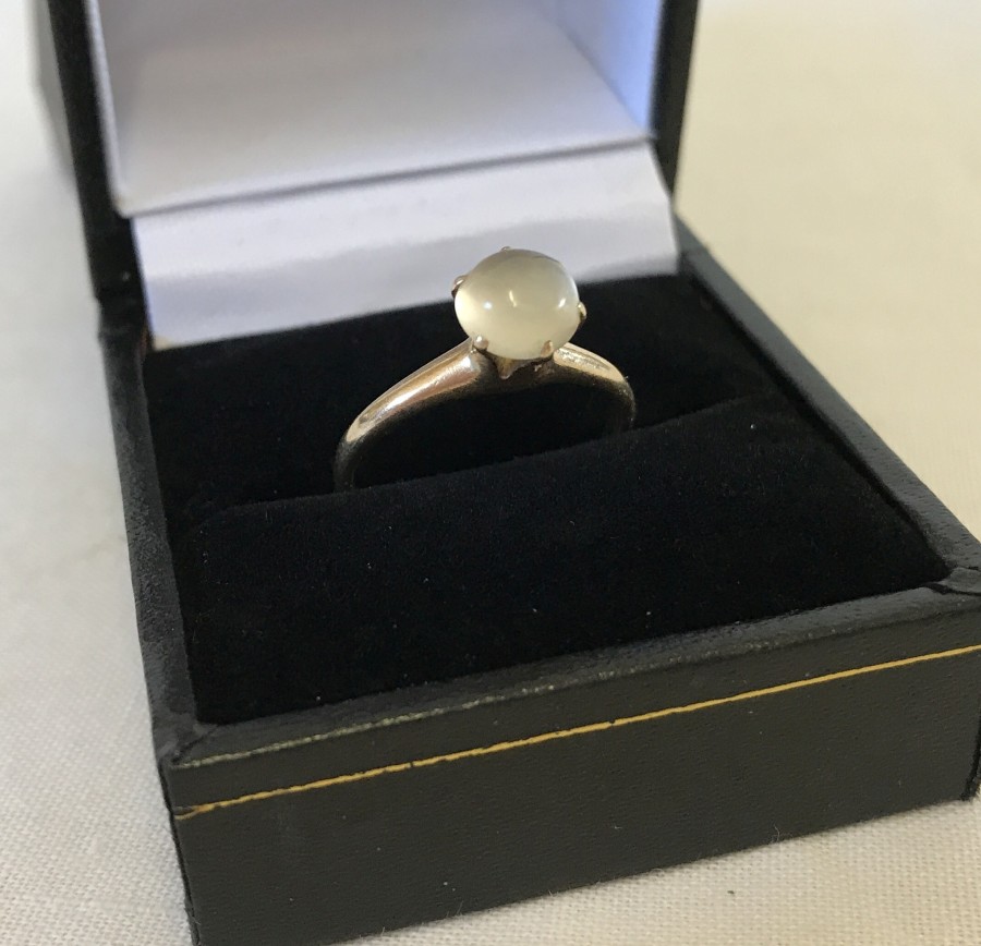 A 14ct ladies ring set with a milky white cabochon stone.