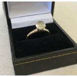 A 14ct ladies ring set with a milky white cabochon stone.