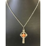 A pewter Celtic cross pendant set with orange stone.