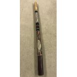 A large wooden didgeridoo with hand painted decoration.