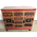 A red painted oriental small sideboard with carved detail to drawers and cupboard doors.