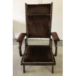 A dark wood folding campaign chair with brown velvet upholstery.