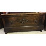 An oak blanket box with diamond design decoration to front.