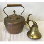 A brass wall hanging bell together with a vintage copper kettle.