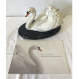 A bisque porcelain figurine "The Royal Swan" on black lacquer plinth with paperwork.