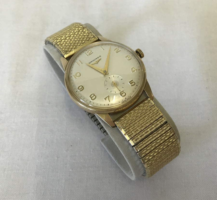 A Longines Gents 9ct gold wristwatch on a rolled gold strap.