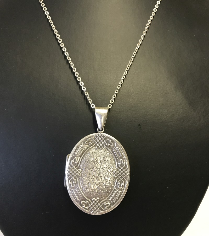 A large oval shaped locket on a silver chain.