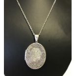 A large oval shaped locket on a silver chain.