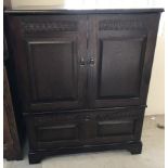 An oak Old Charm style TV cabinet with carved detail to door fronts.